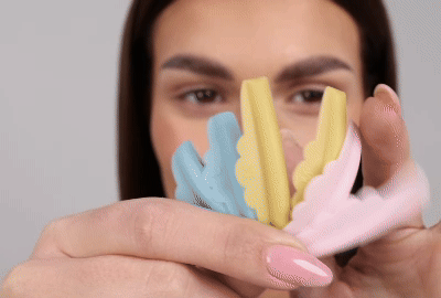 Modelka aplikuje silikonovou tyčinku na horní víčko