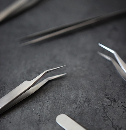 Detailní záběr na pinzetu pro prodlužování řas